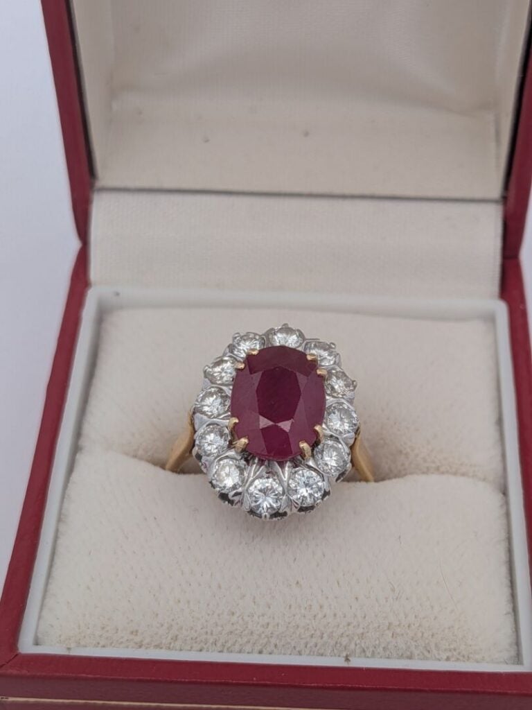 BAGUE "marguerite" en or jaune et or gris (750‰) serti d'un rubis ovale, entour…
