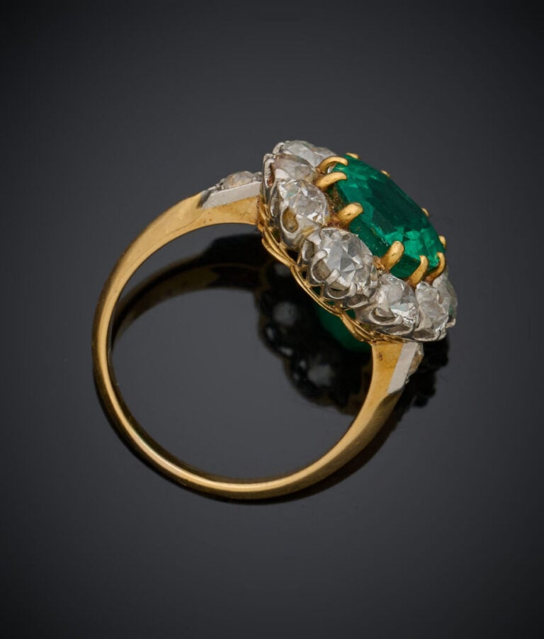 BAGUE "marguerite" en or jaune et or gris (750‰) serti d'une émeraude taillée à…