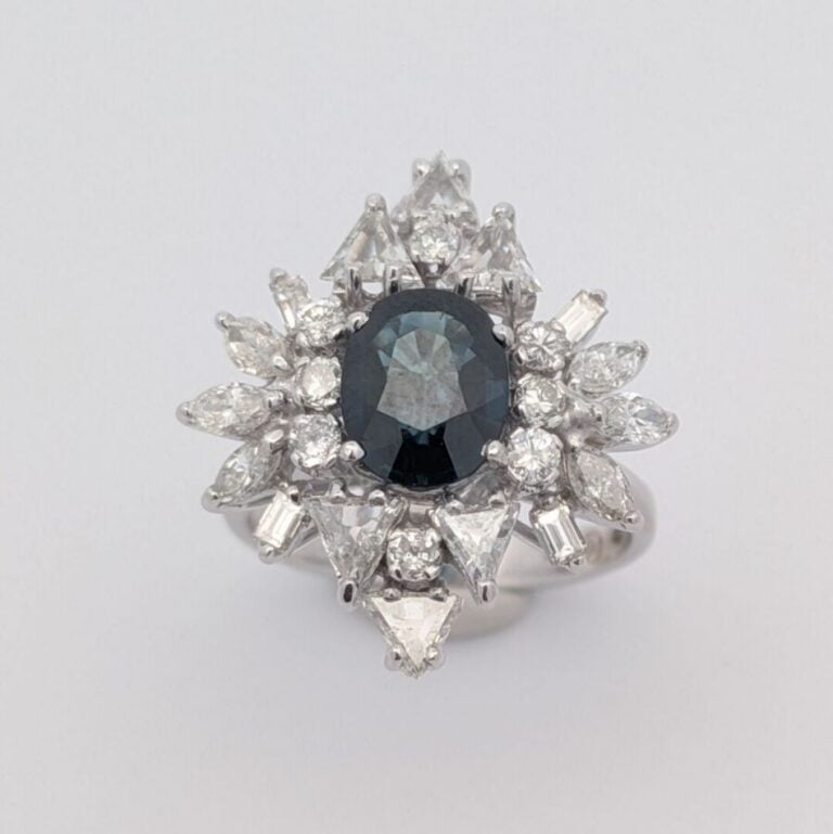 Bague marquise en or blanc (750 ‰) serti d'un saphir ovale entouré de diamants…