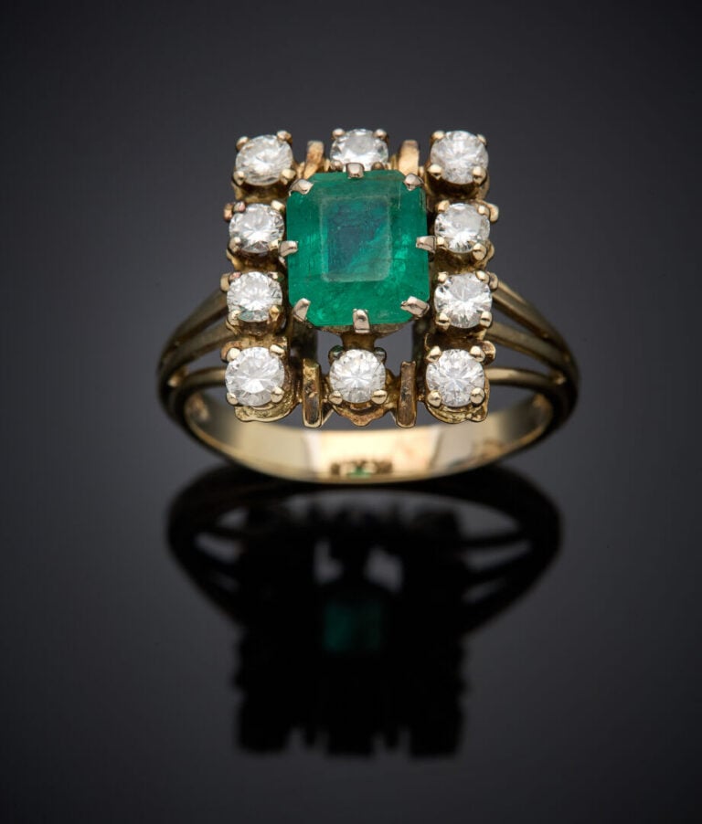 BAGUE rectangulaire en fils d'or gris (750‰) serti d'une émeraude taillée à deg…