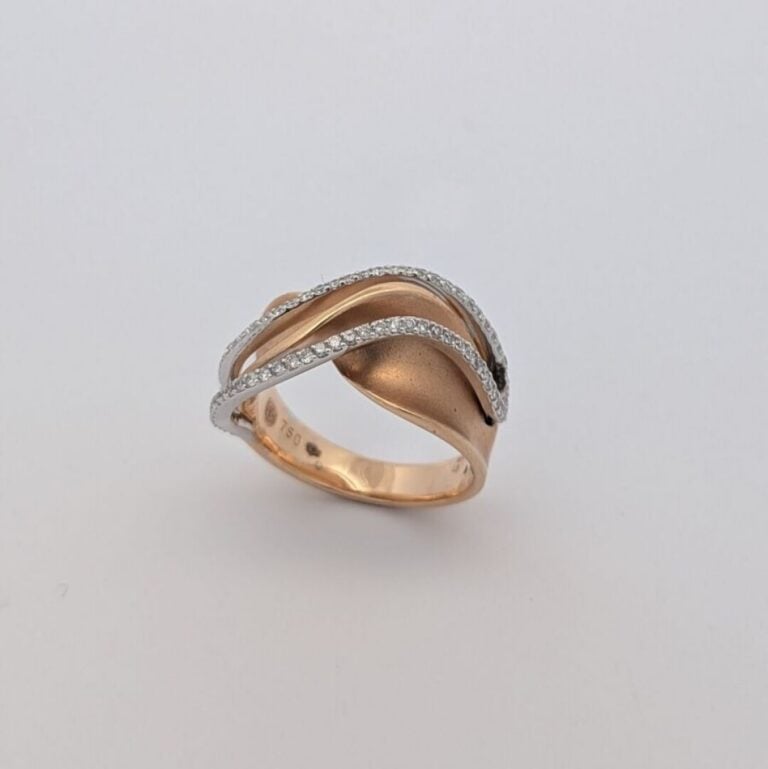 Bague "Vague" en or blanc et or jaune (750 ‰) torsadé satiné serti d'une double…