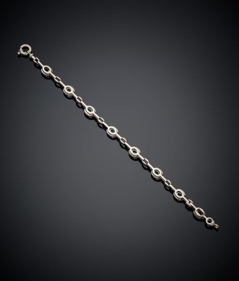 BRACELET articulé en or gris (750‰) serti d'émeraudes ovales entourées de diama…