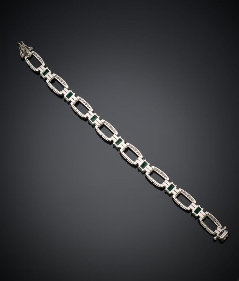 BRACELET en or gris (750‰) ajouré, serti d'émeraudes taillées à degrés et une d…