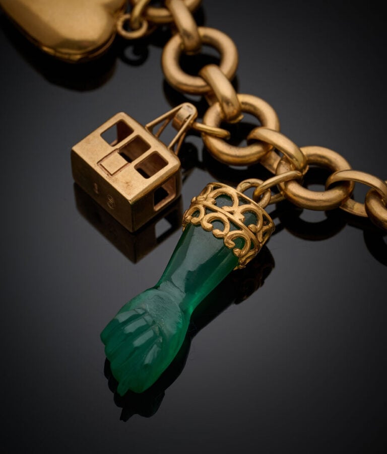 BRACELET en or jaune (750‰) à maille circulaire, retenant huit breloques (carte…