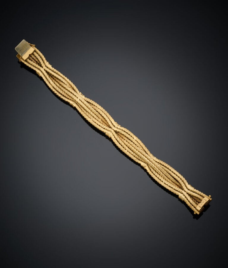 BRACELET en or jaune (750‰) à six brins tressés ponctué d'alignements de diaman…