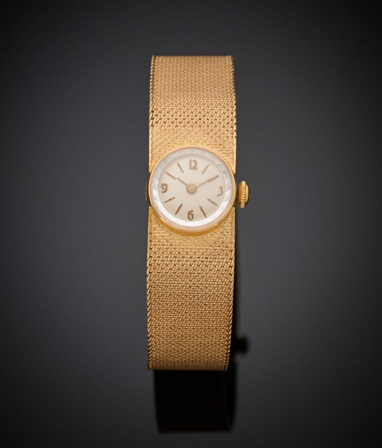 BRACELET MONTRE "ruban" ronde de dame en or jaune (750‰). Cadran crème, chiffre…