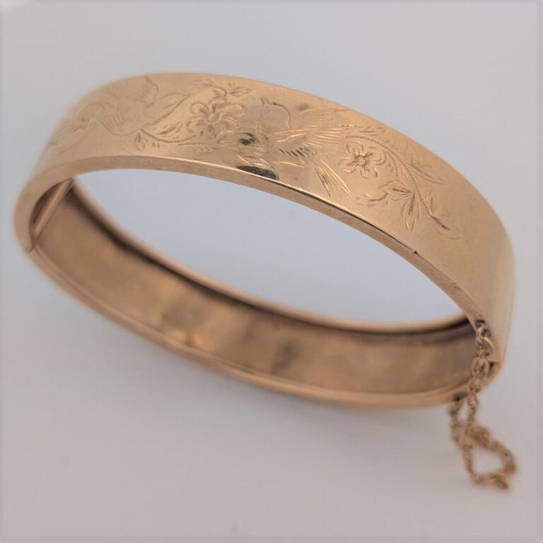BRACELET rigide ouvrant en or jaune (750‰) ciselé à motifs de fleurs et oiseau.…