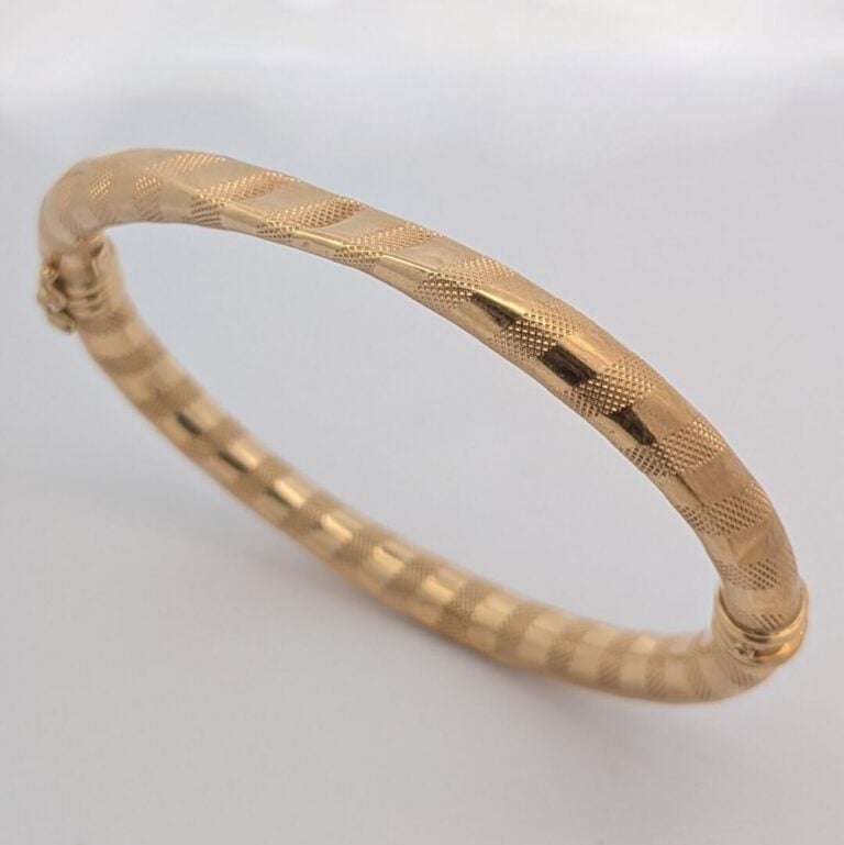BRACELET rigide ouvrant en or jaune (750‰) guilloché. Chocs. - Long.: 17,8 cm.…