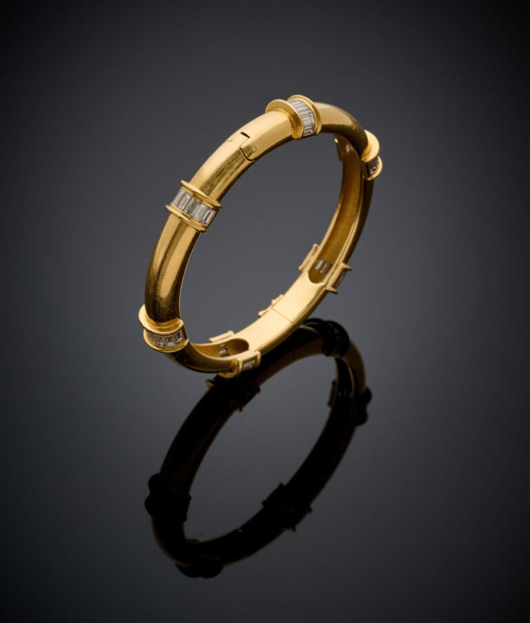 BRACELET rigide ouvrant en or jaune (750‰) ponctué de six alignements de diaman…