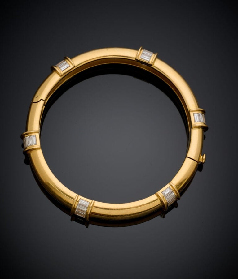 BRACELET rigide ouvrant en or jaune (750‰) ponctué de six alignements de diaman…