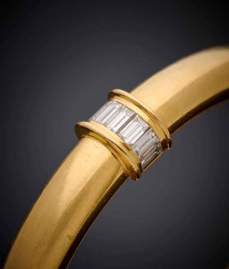BRACELET rigide ouvrant en or jaune (750‰) ponctué de six alignements de diaman…
