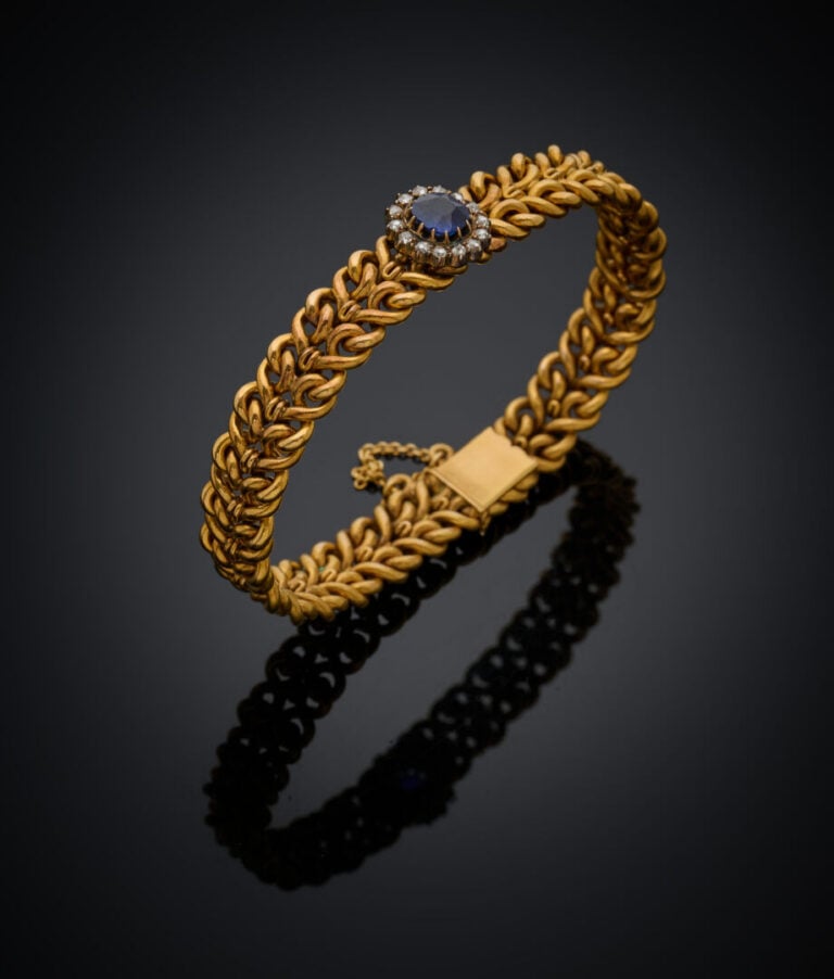 BRACELET souple en or jaune (750‰) ajourés, centré d'un motif "marguerite" sert…
