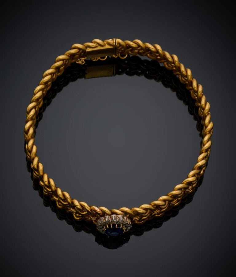 BRACELET souple en or jaune (750‰) ajourés, centré d'un motif "marguerite" sert…