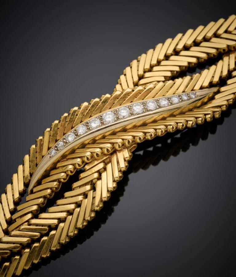 BRACELET souple en or jaune et or gris (750‰) tressé, serti au centre d'un alig…