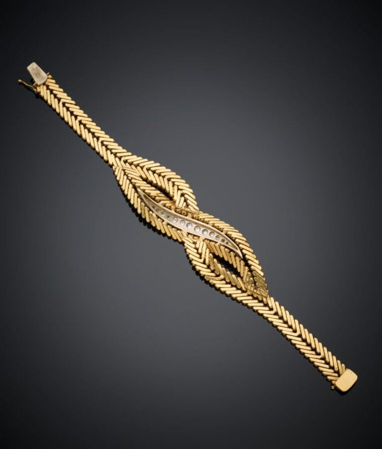 BRACELET souple en or jaune et or gris (750‰) tressé, serti au centre d'un alig…