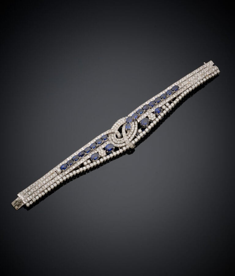 BRACELET "volutes" articulé en or gris (750‰) ajouré, serti de diamants taille…