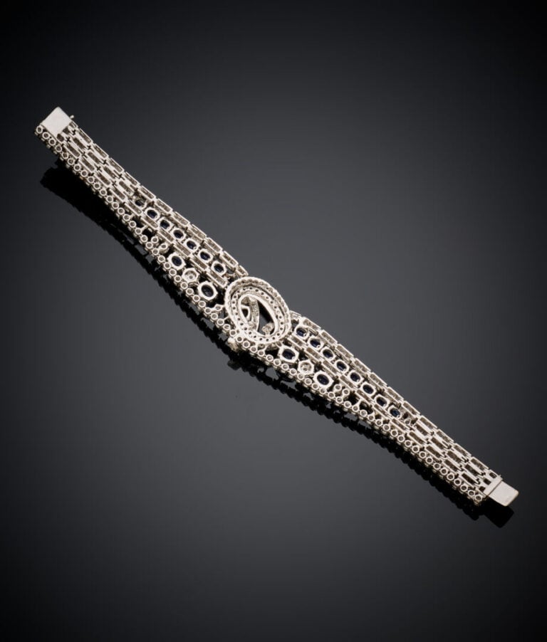 BRACELET "volutes" articulé en or gris (750‰) ajouré, serti de diamants taille…