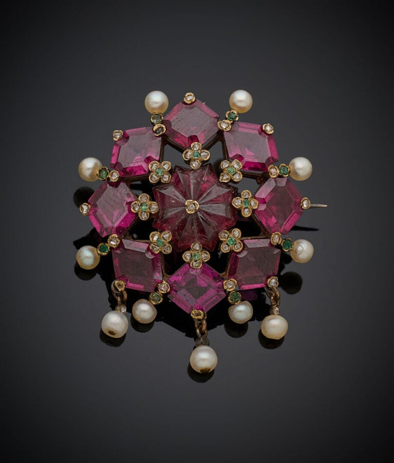BROCHE "fleur" en or jaune (750‰) et argent (800‰) serti de grenats rhodolites…