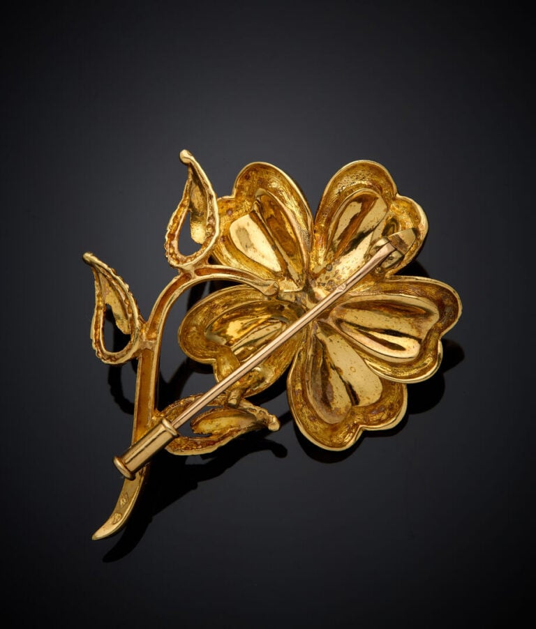BROCHE "fleur" en or jaune (750‰) partiellement amati, le pistil composé de dia…