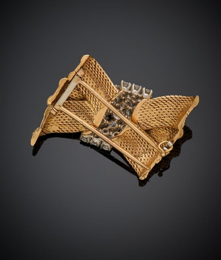 BROCHE "nœud" en or jaune et or gris (750‰) à maille tissée, serti de 21 diaman…