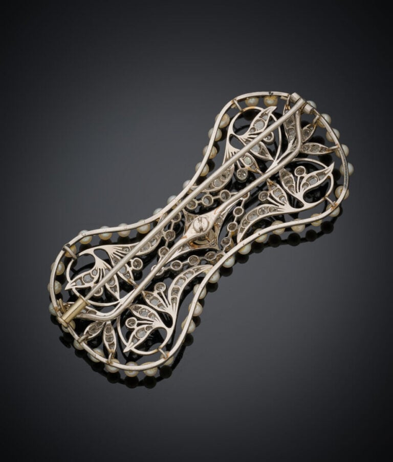 BROCHE "nœud" en platine (min.800‰) et or gris (750‰} ajouré, serti de petits d…