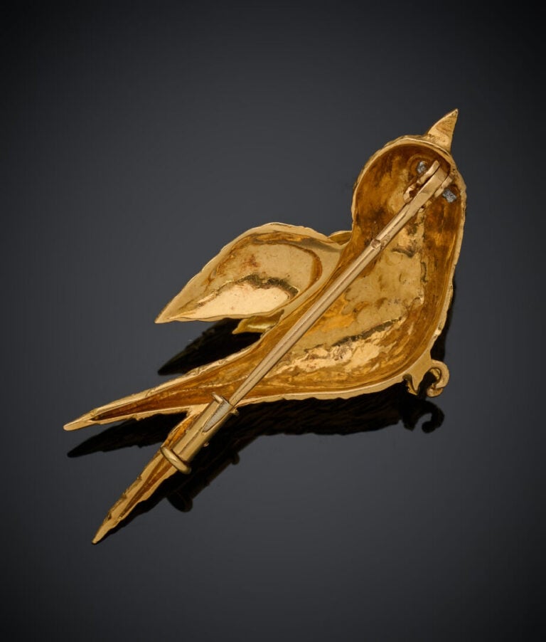BROCHE "oiseau" en or jaune (750‰) ciselé, serti d'une pierre rose ronde taillé…
