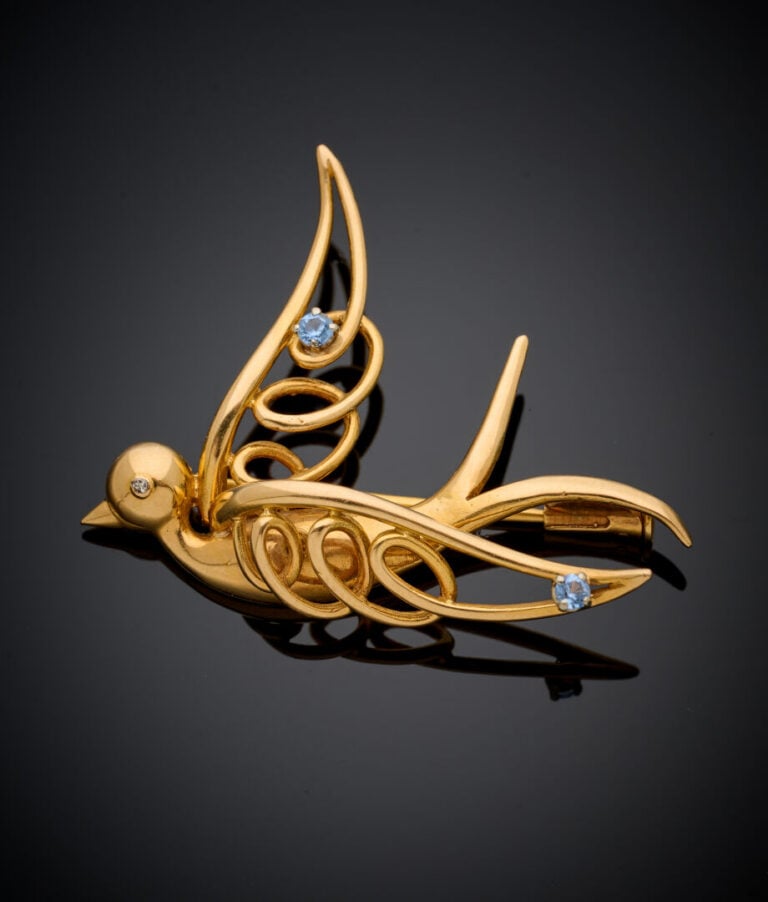 BROCHE "oiseau en vol" en or jaune (750‰), les ailes ajourées ponctuées de peti…
