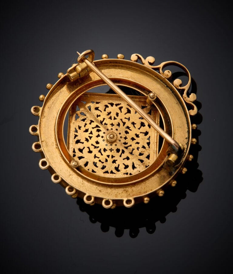 BROCHE PENDENTIF circulaire en or jaune (750‰) repercé et ciselé, serti de turq…