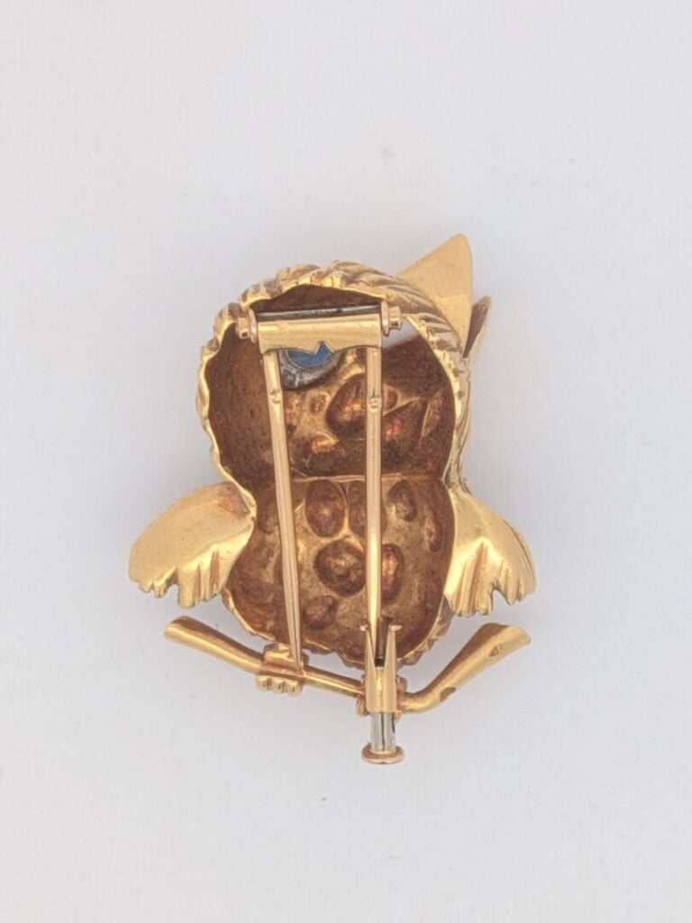 CLIP de CORSAGE "oiseau" en or jaune (750‰) godronné et sculpté. L'œil serti d'…