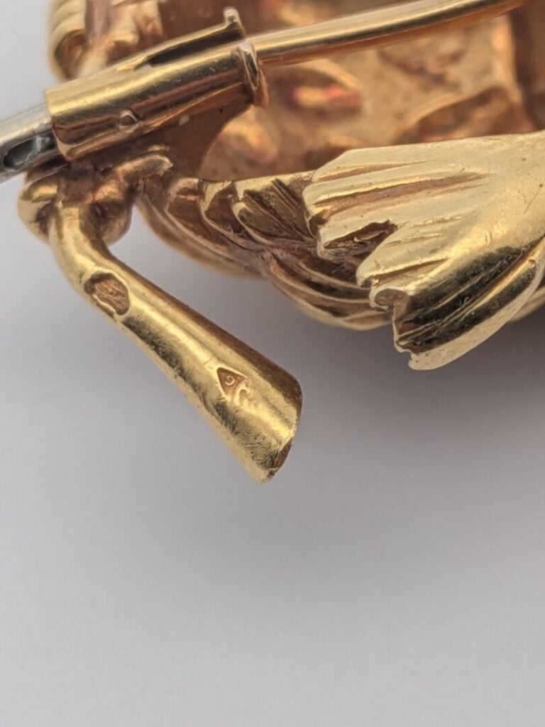 CLIP de CORSAGE "oiseau" en or jaune (750‰) godronné et sculpté. L'œil serti d'…