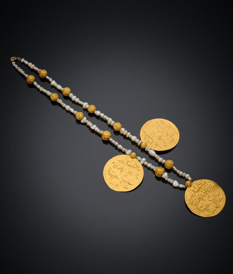 COLLIER composé de perles d'eau douce alternées de boulles et trois médaillons…