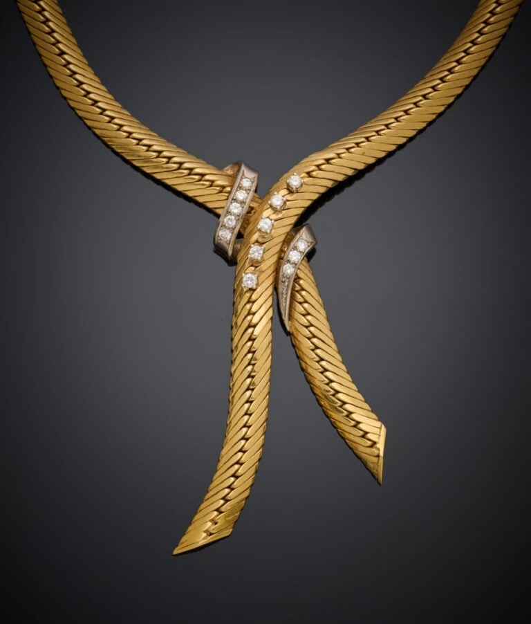 COLLIER "cravate" souple en or jaune et or gris (750‰) orné d'un volute central…