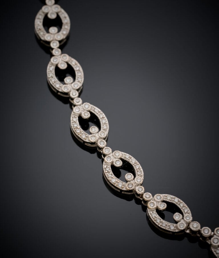 COLLIER en or gris (750‰) articulé, à maillons ovales ajourés, articulés serti…