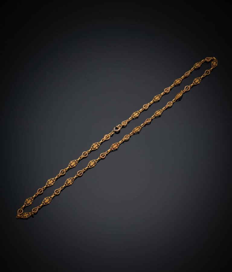 COLLIER en or jaune (750‰) ajouré, à maille filigranée "lyres" et ovales altern…