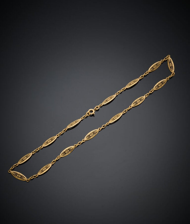 COLLIER en or jaune (750‰) ajouré, à maille navette filigranée. - Travail franç…