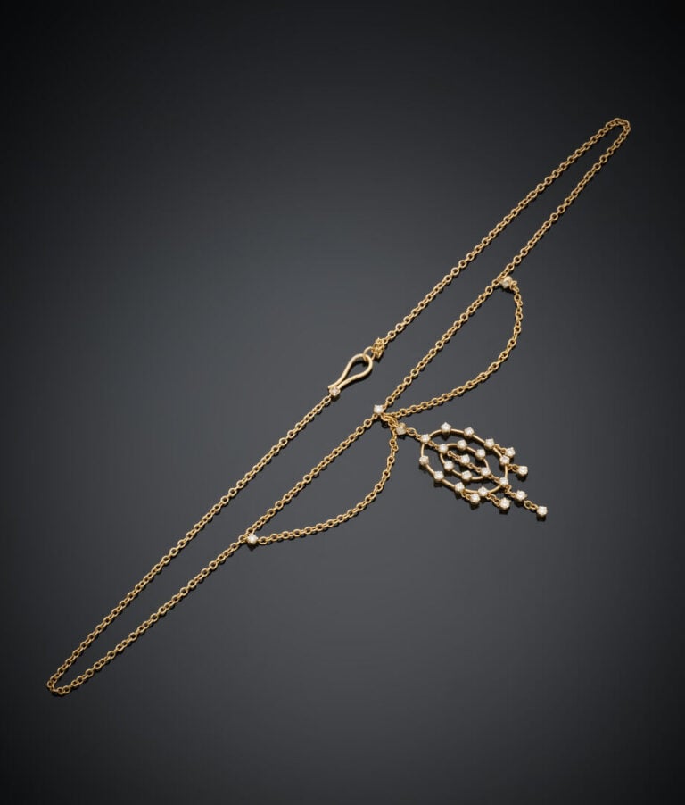 COLLIER et sa chaînette en or jaune (750‰) ajouré retenant un PENDENTIF serti d…