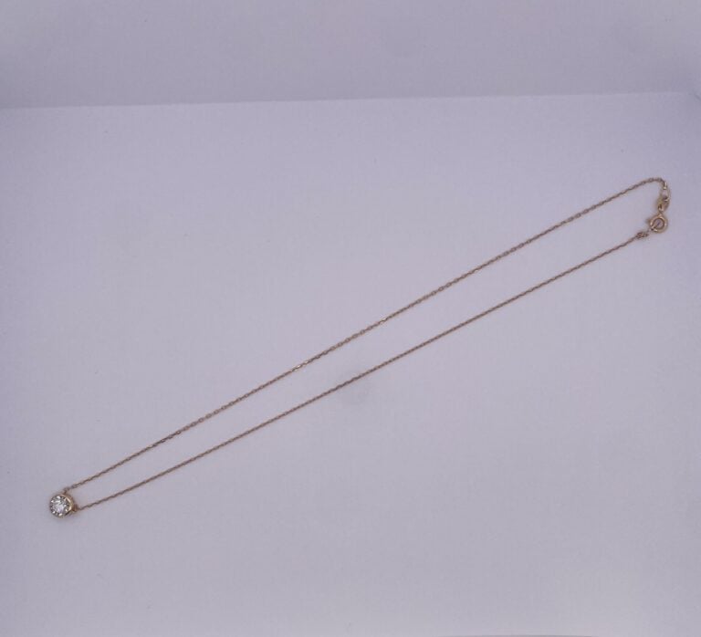 COLLIER et sa chaînette en or rose et or gris (750‰) guilloché, retenant un dia…
