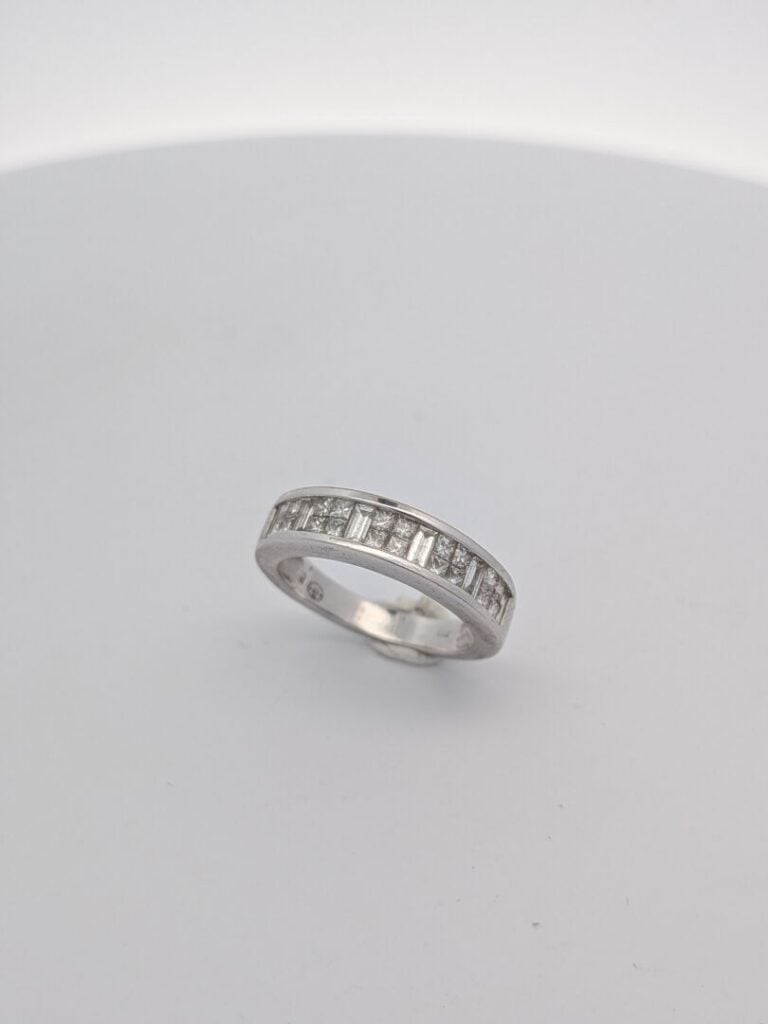 DEMI-ALLIANCE en or gris (750‰) serti de diamants taille baguette et princesse.…