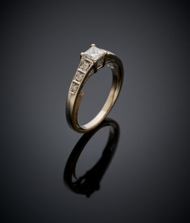 Fine BAGUE en or gris (750‰) serti d'un diamant taille princesse épaulé d'une l…