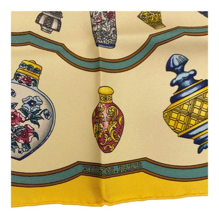 HERMÈS - Petit carré Gavroche en soie à motifs de flacons de parfums sur fond c…