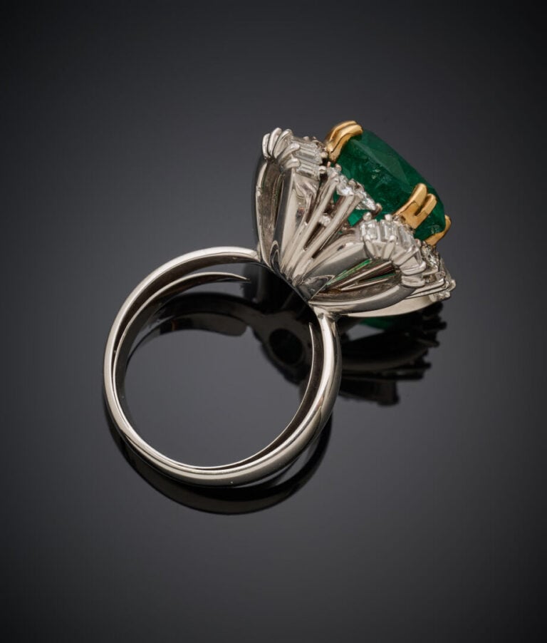 Importante BAGUE en or jaune et or gris (750‰) serti d'une émeraude ronde entou…