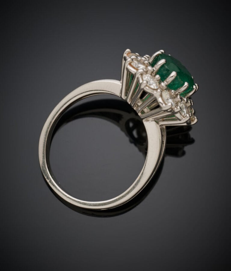 Importante BAGUE "marguerite" en or gris (750‰) serti d'une émeraude ovale, ent…