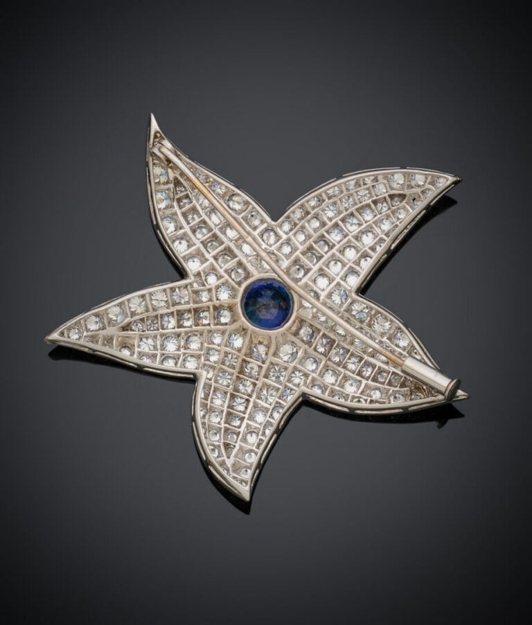 Importante BROCHE "fleur" en or gris (750‰) serti d'un saphir rond rapporté, en…