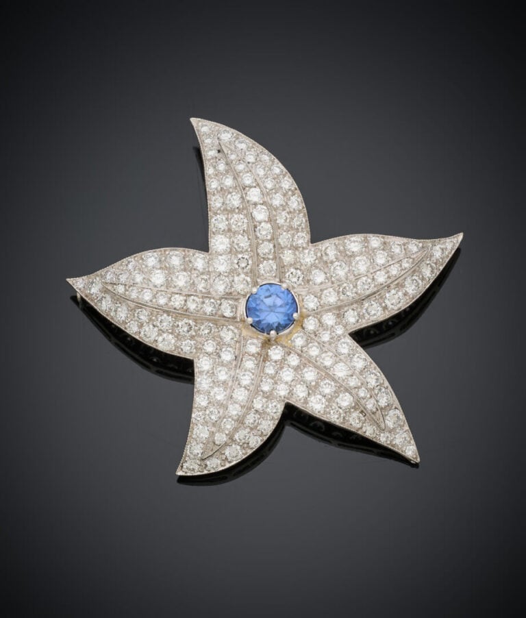 Importante BROCHE "fleur" en or gris (750‰) serti d'un saphir rond rapporté, en…