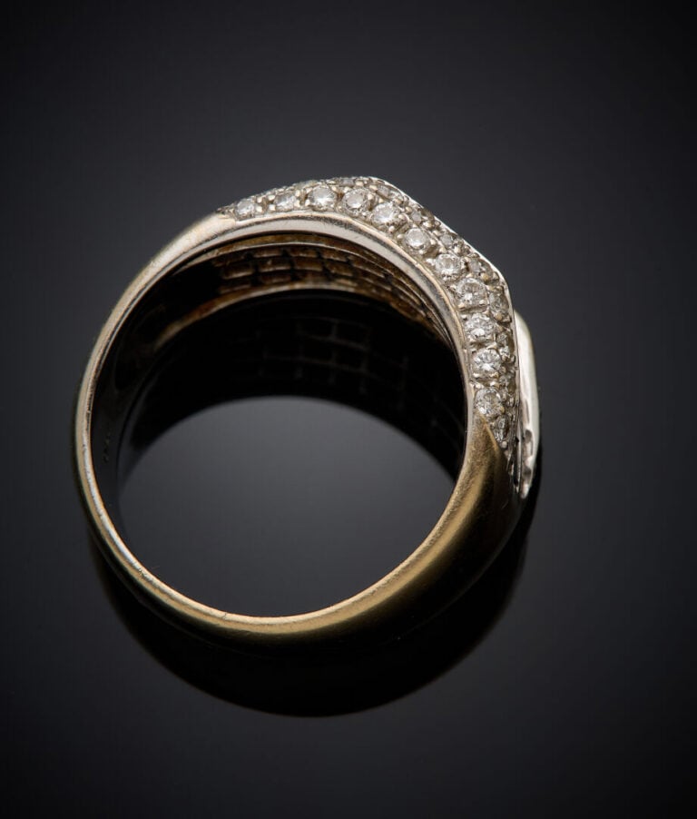 Large BAGUE en or gris (750‰) ornée de saphirs calibrés en serti invisible, ent…