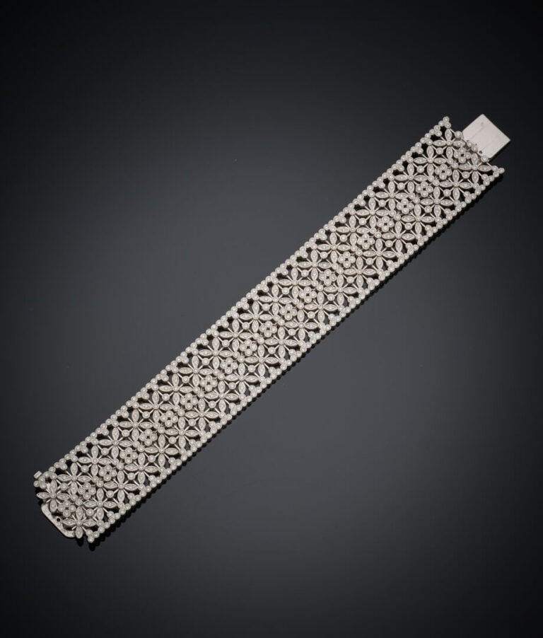 Large BRACELET souple manchette en or gris (750‰) ajouré, à motif de fleurettes…