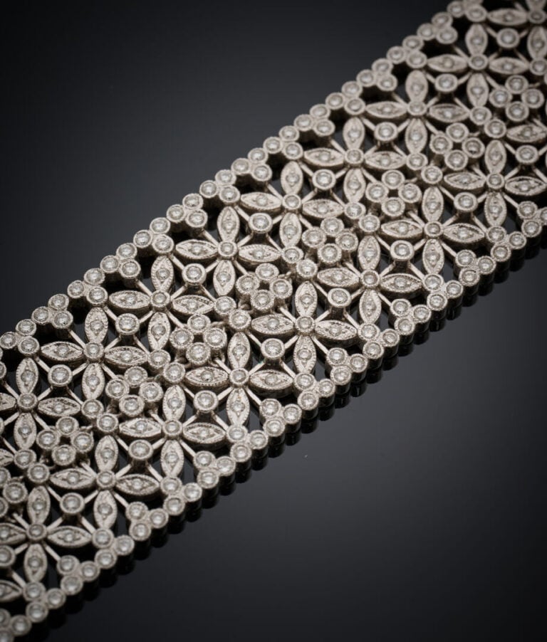 Large BRACELET souple manchette en or gris (750‰) ajouré, à motif de fleurettes…
