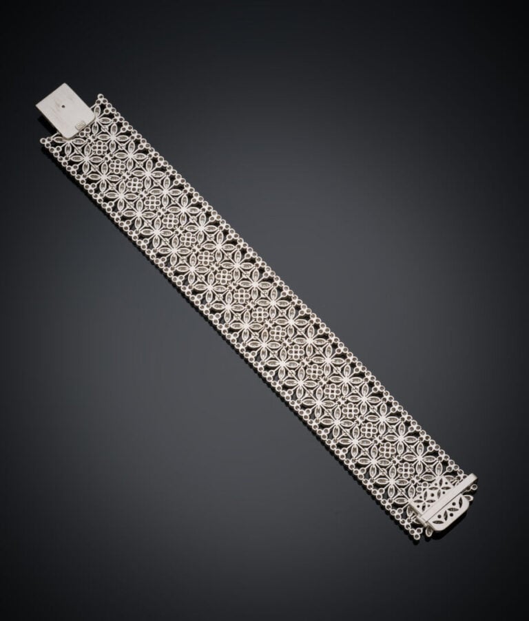 Large BRACELET souple manchette en or gris (750‰) ajouré, à motif de fleurettes…