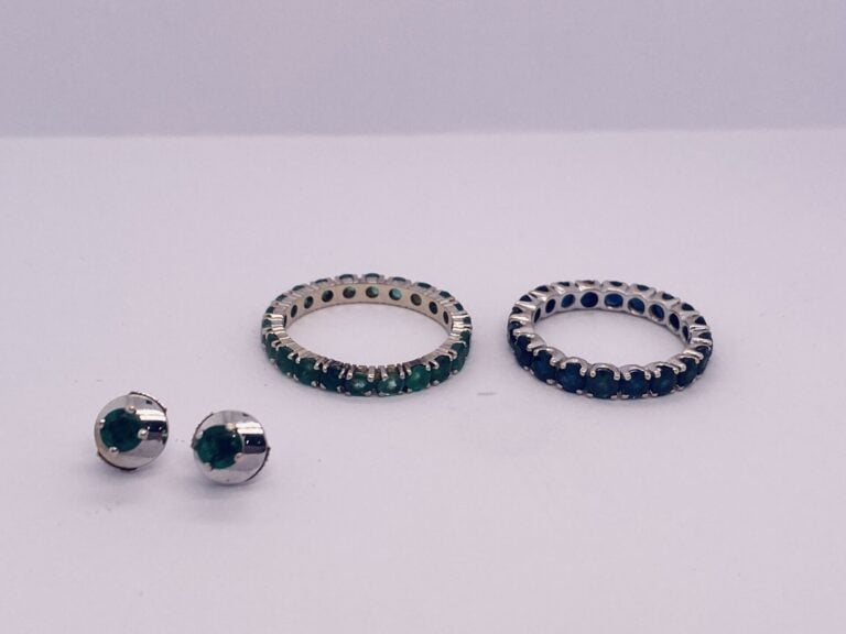 LOT en or gris (750‰) comprenant : - - Deux ALLIANCES, l'une sertie d'émeraudes…