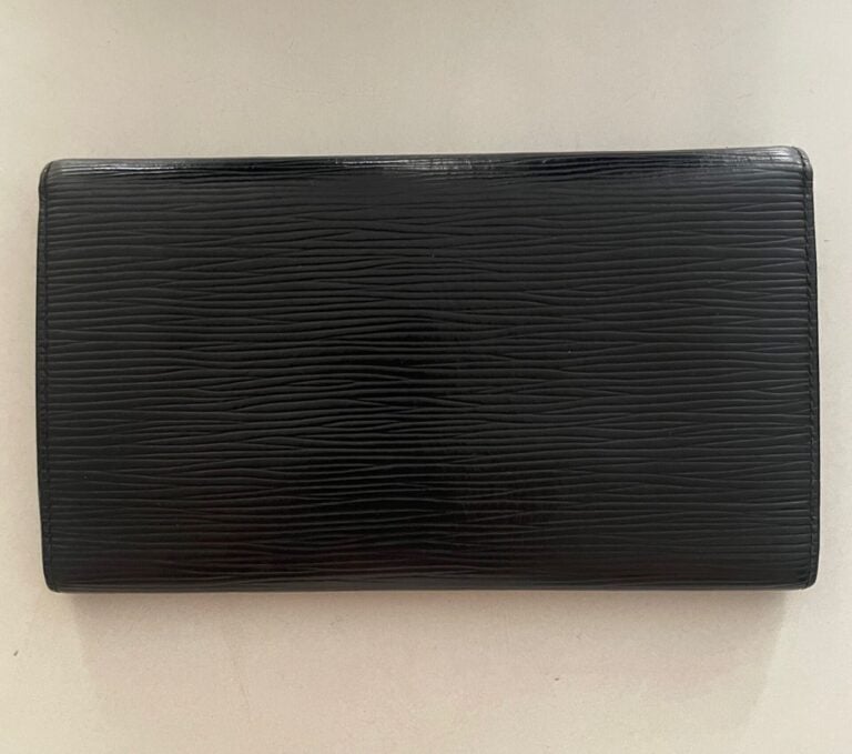 LOUIS VUITTON ANNÉE 1993 - Portefeuille en cuir épi noir, compartiments cartes,…
